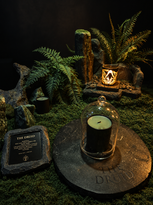THE DRUID scented candle in a dark earth-inspired setting